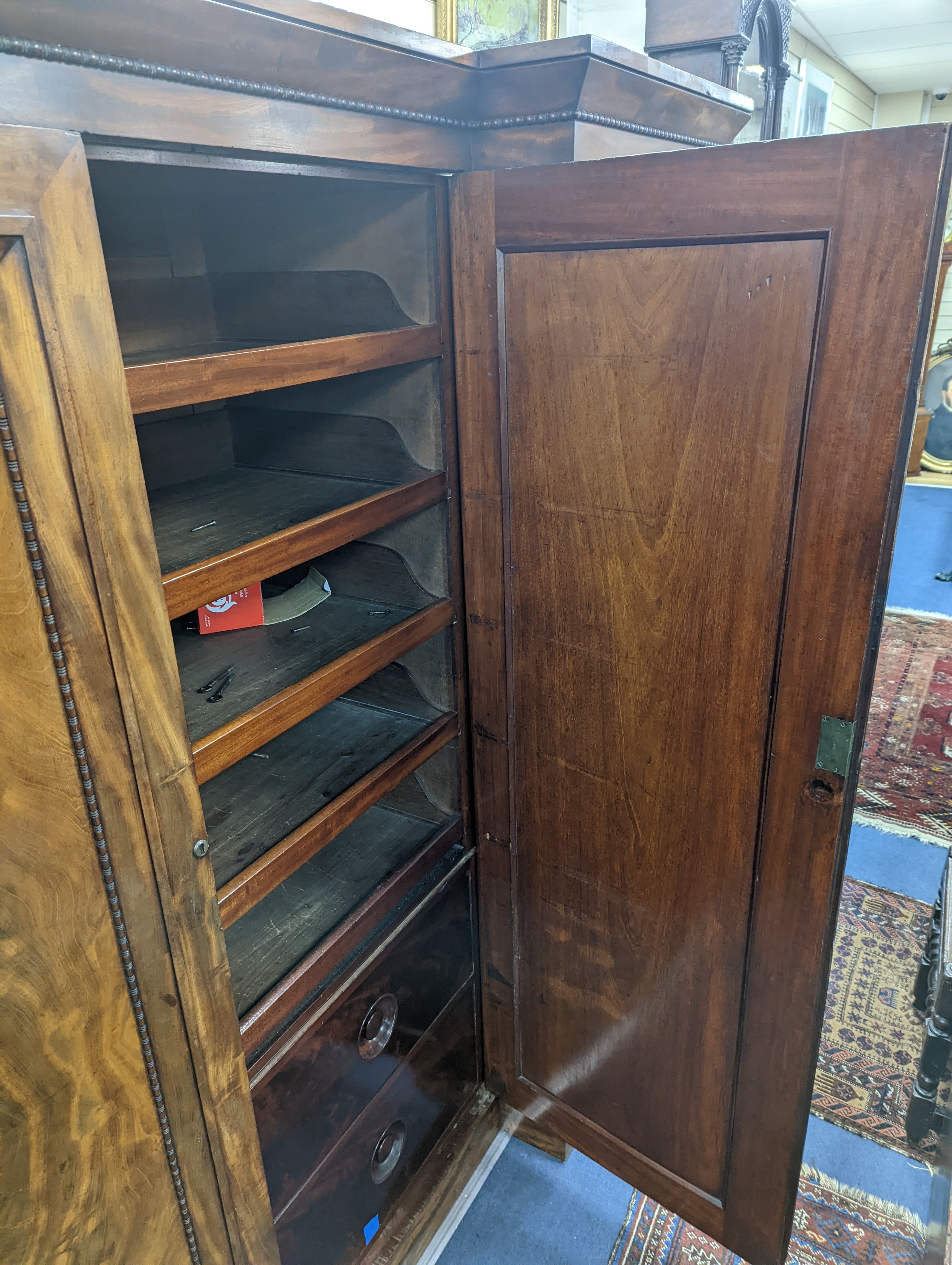 A William IV figured mahogany inverse breakfront compactum wardrobe, length 263cm, depth 70cm, height 197cm